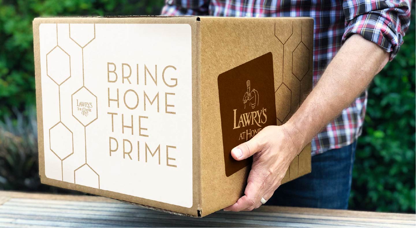 man carrying a shipping box labelled Bring Home the Prime